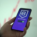 Pessoa segura um smartphone que exibe uma carteira digital de criptomoedas baseada em blockchain.