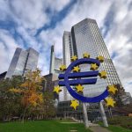 Escultura do euro diante de arranha-céus no distrito financeiro de Frankfurt, na Alemanha